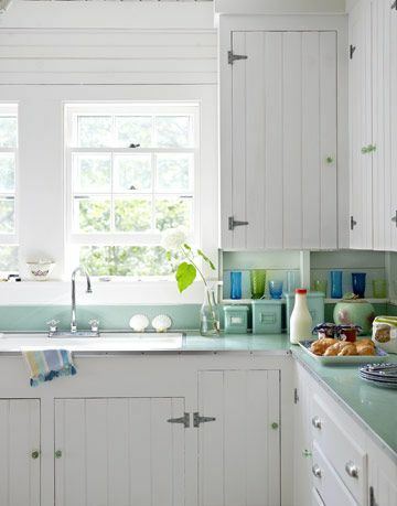 valkoiset keittiönkaapit ikkunat vihreät laskurit