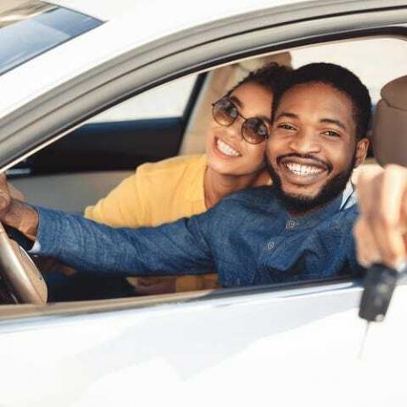 afroamerikkalaiset puolisot näyttävät uuden auton avaimen istumassa autossa