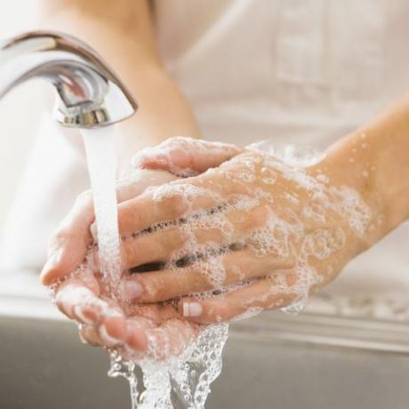Valkoihoinen nainen pesee kätensä