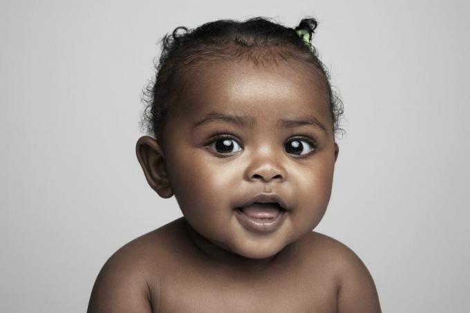 tyttövauva, joka on 6-9 kuukautta hymyilevä, muotokuva