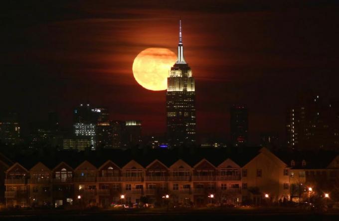 Täysikuu nousee Empire State Buildingin takaa New Yorkissa