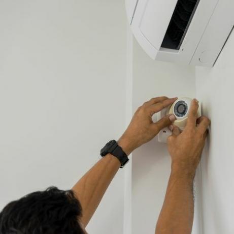 rajattu käsimies asentamalla CCTV: n seinälle kotona
