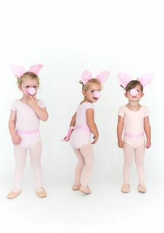 pienet tytöt vaaleanpunaisissa sukkahousuissa ja pikkuhousut, joilla on sian korvat ja sian kuono