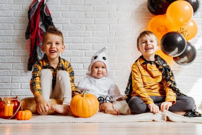 puvut pukeutuvat lapset juhlivat halloweenia valkoinen tiiliseinä koristeilla kopiointitilaa