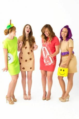neljä naurettavaa naista lyhyillä mekkoilla pukeutuneena "lounas naisiksi", joista yhdessä on keltainen hymiö kasvot lounasrasia